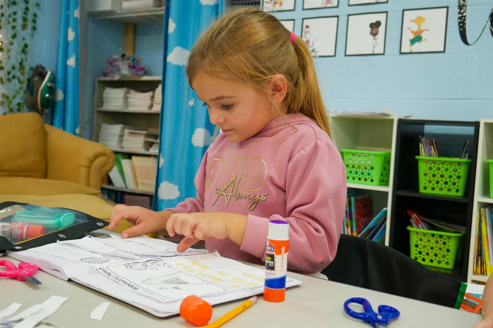 girl gluing paper